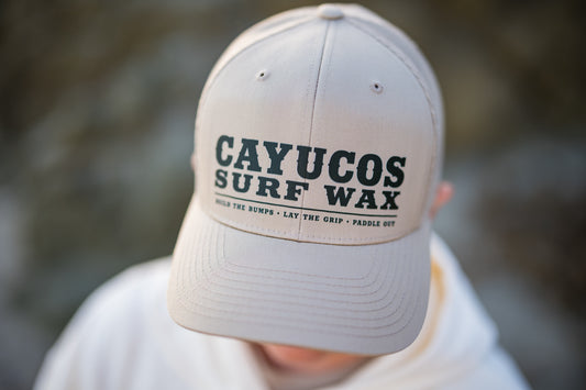 Khaki trucker hat with embroidered navy Cayucos Surf Wax Heritage logo