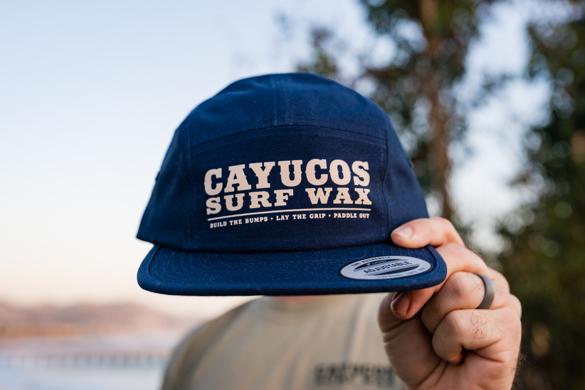 Raised view of Cayucos Surf Wax navy blue flat brimmed jockey cap with adjustable closure